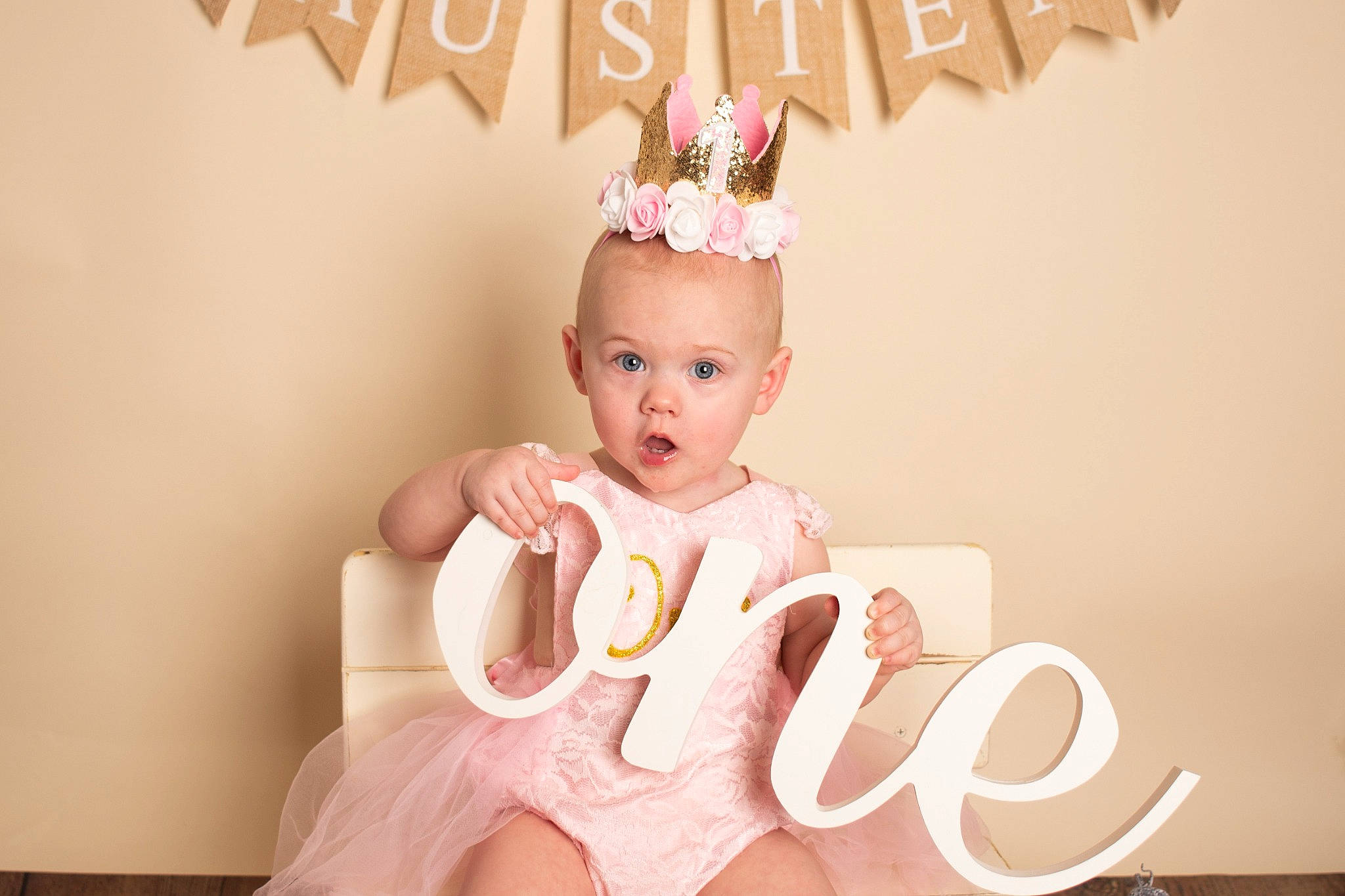 Austen is registered to the contest to win money with this photo: baby, baby_toddler_clothing, birthday, cake, cake_decorating, costume_hat, crown, dress, event, happy, headband, headgear, headpiece, party_supply, peach, person, pink, skin, sleeve, surprise