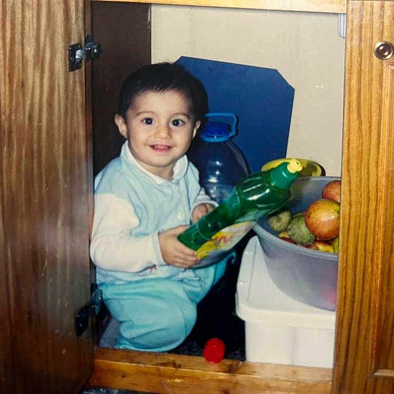 Bıdıskom joined the competition — help win amazing prizes! apple, baby, bottle, cabinet, child, clothing, container, curious, door, fruit, happy, household, indoor, kitchen, person, plastic_bowl, sitting, smile, toddler, wood