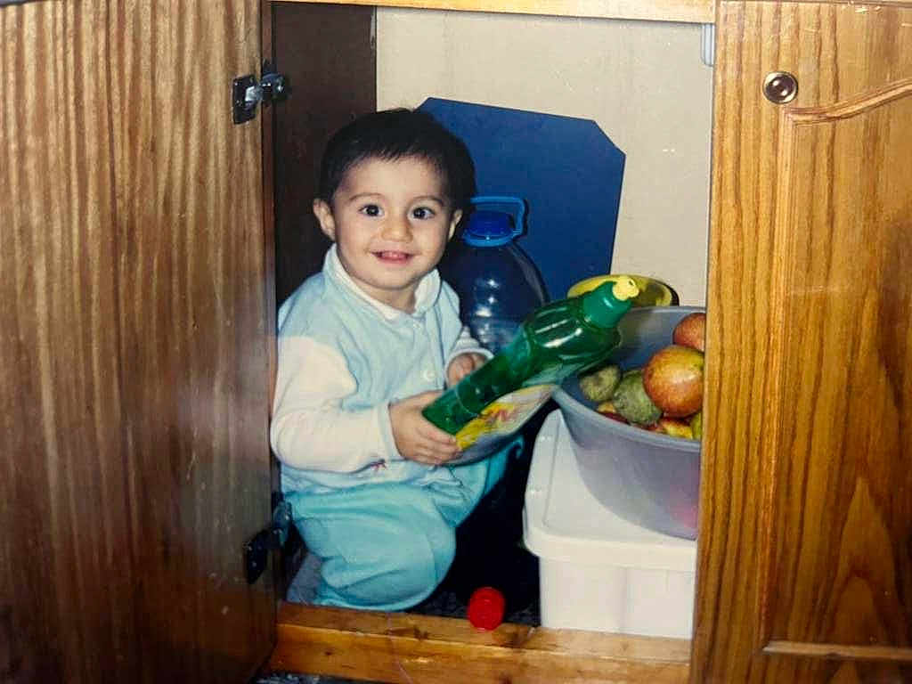 Bıdıskom joined the competition — help win amazing prizes! apple, baby, bottle, cabinet, child, clothing, container, curious, door, fruit, happy, household, indoor, kitchen, person, plastic_bowl, sitting, smile, toddler, wood