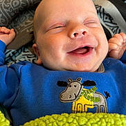 Oakley joined the competition — help win amazing prizes! baby, smiling, blue_clothing, blanket, moose_design, face, happy, infant, patterned_fabric, cozy, child, closeup, cute, small_hands, resting, lying_down, indoors, soft_texture, warm, sleepy