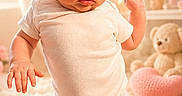Lily is registered to the contest to win money with this photo: baby, child, white_shirt, pink_skirt, knitted, carpet, indoor, teddy_bear, heart_shape, decor, soft_lighting, curious, standing, person, portrait, cute, fluffy, room, young, infant