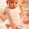 baby, child, white_shirt, pink_skirt, knitted, carpet, indoor, teddy_bear, heart_shape, decor, soft_lighting, curious, standing, person, portrait, cute, fluffy, room, young, infant