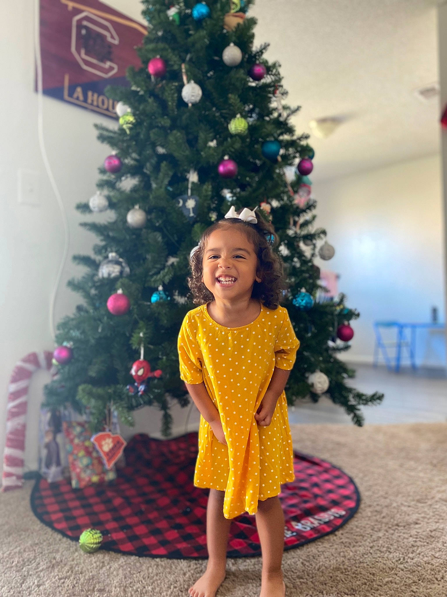 Teagan joined the competition — help win amazing prizes! christmas, christmas_decoration, christmas_ornament, christmas_tree, dress, event, evergreen, fun, happy, holiday, holiday_ornament, human_body, joy, leaf, magenta, ornament, person, plant, smile, toddler