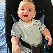 Alessio participe au concours pour gagner de l'argent avec cette photo : baby, child, smiling, polo_shirt, denim_shorts, baby_seat, cushion, happy, indoor, person, infant, cute, clothing, seatbelt, blue, jeans, portrait, young, sitting, bright