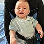 baby, child, smiling, polo_shirt, denim_shorts, baby_seat, cushion, happy, indoor, person, infant, cute, clothing, seatbelt, blue, jeans, portrait, young, sitting, bright