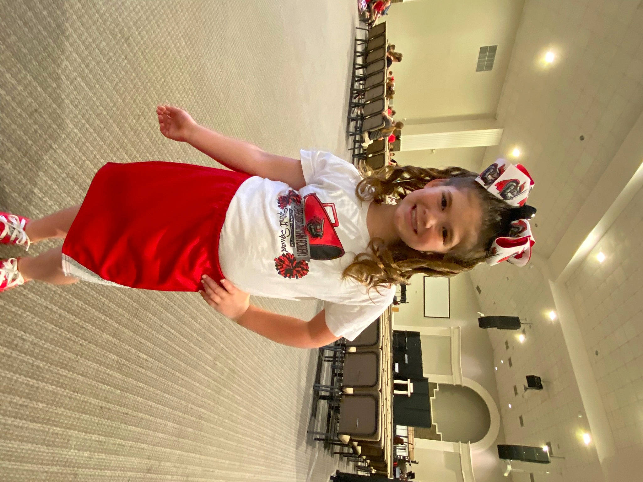 Emma is registered to the contest to win money with this photo: carmine, child, costume, elbow, entertainment, event, fashion_design, flooring, fun, happy, human_leg, joy, performance, performing_arts, person, room, shorts, smile, t_shirt, thigh
