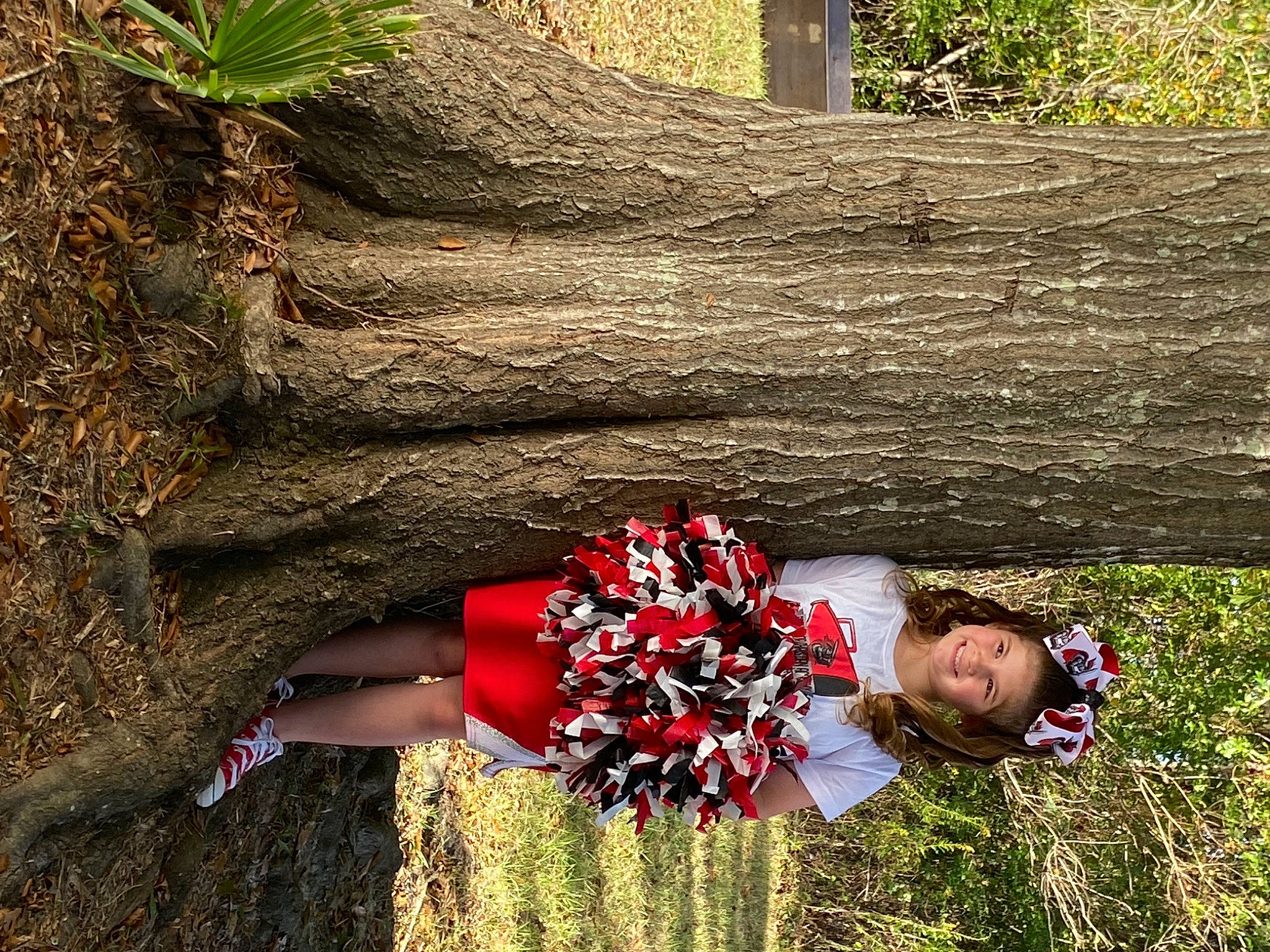 Emma is registered to the contest to win money with this photo: adaptation, flower, fun, grass, grass_family, happy, human_leg, joy, leisure, people_in_nature, person, plant, shrub, sitting, soil, spring, thigh, tree, trunk, waist