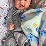 Prosper is registered to the contest to win money with this photo: baby, infant, smiling, pajamas, blanket, cushion, seat, face, hand, footwear, heart_lights, indoor, comfort, cute, child, portrait, happy, cozy, infantwear, babygear