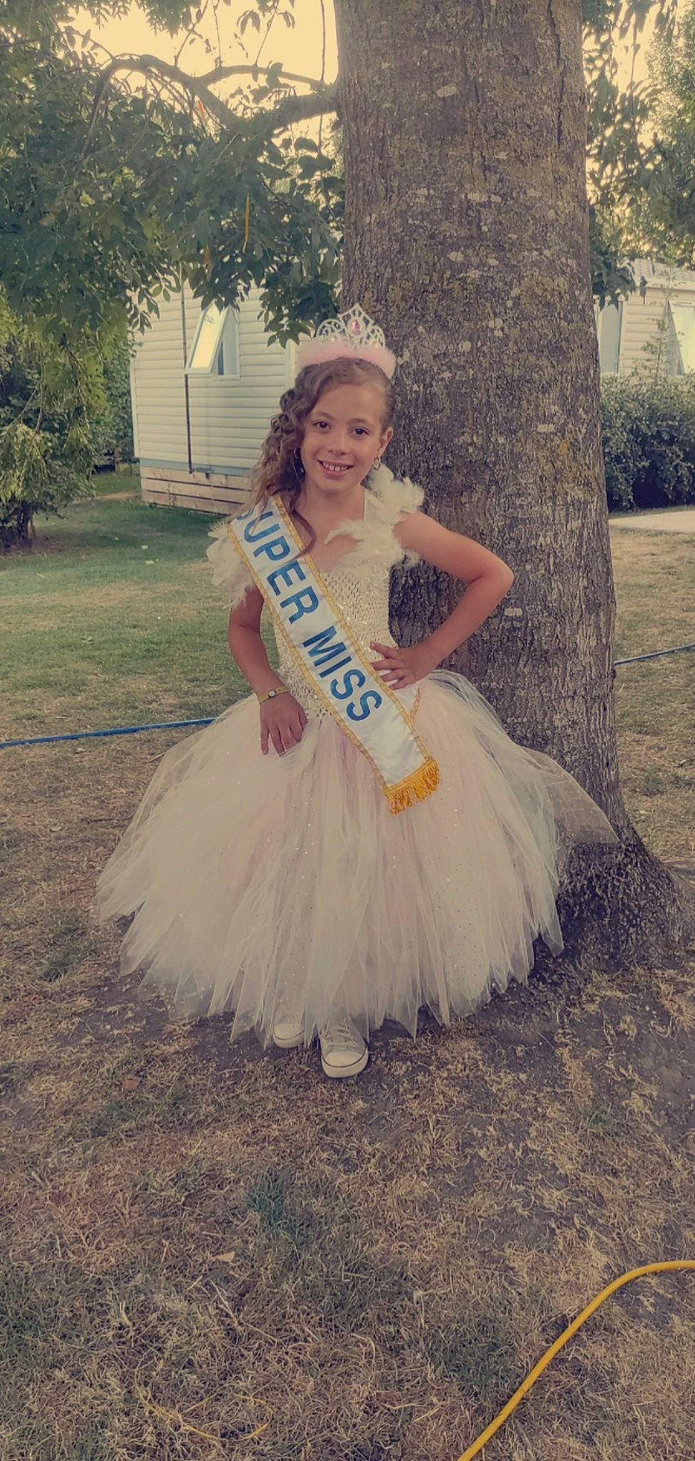 Abby a rejoint le concours — aidez-le/la à gagner de superbes lots ! bridal_accessory, bridal_clothing, bridal_party_dress, dress, embellishment, face, fashion_design, flash_photography, formal_wear, gown, grass, happy, headpiece, joy, long_hair, person, plant, ruffle, smile, tree