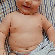 Sammuel joined the competition — help win amazing prizes! baby, bare_chested, bed, black_border, blanket, child, close_up, diaper, eyes, face, happy, indoor, infant, lying_down, phone_screen, photograph, portrait, relaxed, smiling, striped_bedding