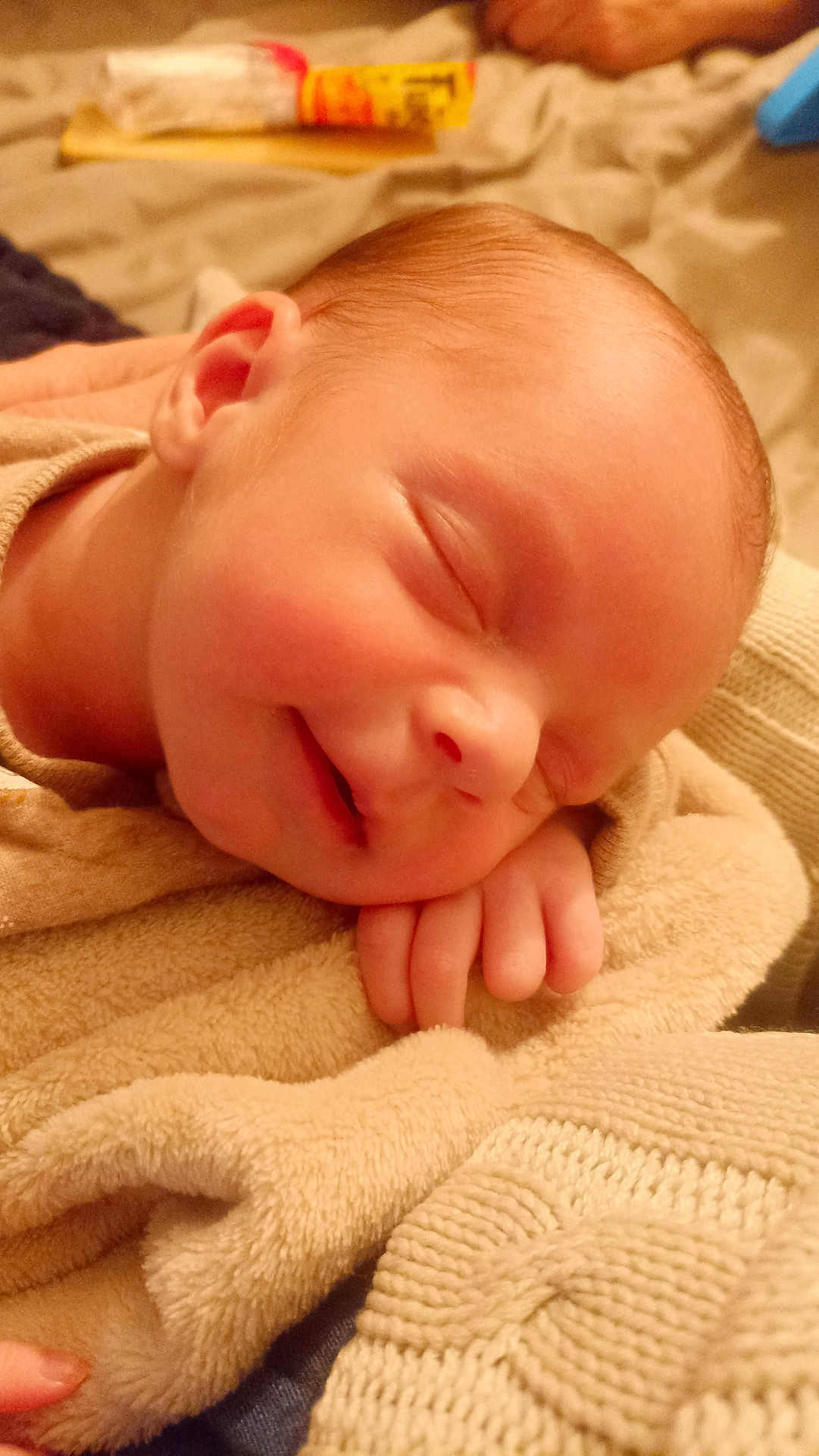 Arthur a rejoint le concours — aidez-le/la à gagner de superbes lots ! baby, newborn, sleeping, blanket, hand, cozy, soft, smile, infant, face, skin, peaceful, closeup, warm, knitted, cuddle, child, resting, indoors, portrait