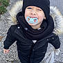Thomas participe au concours pour gagner de l'argent avec cette photo : child, pacifier, winter_coat, black_hat, smiling, outdoor, pavement, toy, white_shoes, jeans, cold_weather, happy, standing, cute, face, person, accessory, fur_hood, scarf, walking