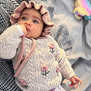 Althea a rejoint le concours — aidez-le/la à gagner de superbes lots ! baby, blanket, bonnet, checkered_pattern, child, closeup, cozy, cute, expression, floral_pants, indoors, infant, knitted_sweater, person, portrait, relaxed, soft_lighting, thumb_sucking, toy, young_child