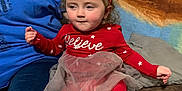 Lilah is registered to the contest to win money with this photo: child, red_clothing, santa_hat, holiday, toddler, indoor, couch, festive, boots, tulle_skirt, person, cute, holiday_season, smiling, headwear, plush, cozy, home, sitting, young_child