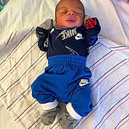 Jermaine joined the competition — help win amazing prizes! newborn, baby, sleeping, clothing, nike, towel, striped_towel, sock, mittens, infant, person, bed, resting, cute, small, peaceful, indoor, laying, apparel, child