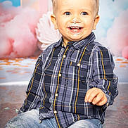 Djino a rejoint le concours — aidez-le/la à gagner de superbes lots ! toddler, child, smiling, plaid_shirt, jeans, cake_frosting, face_paint, sitting, happy, indoor, portrait, blue_eyes, blond_hair, background_decoration, party, messy, floor, casual_clothing, cute, celebration
