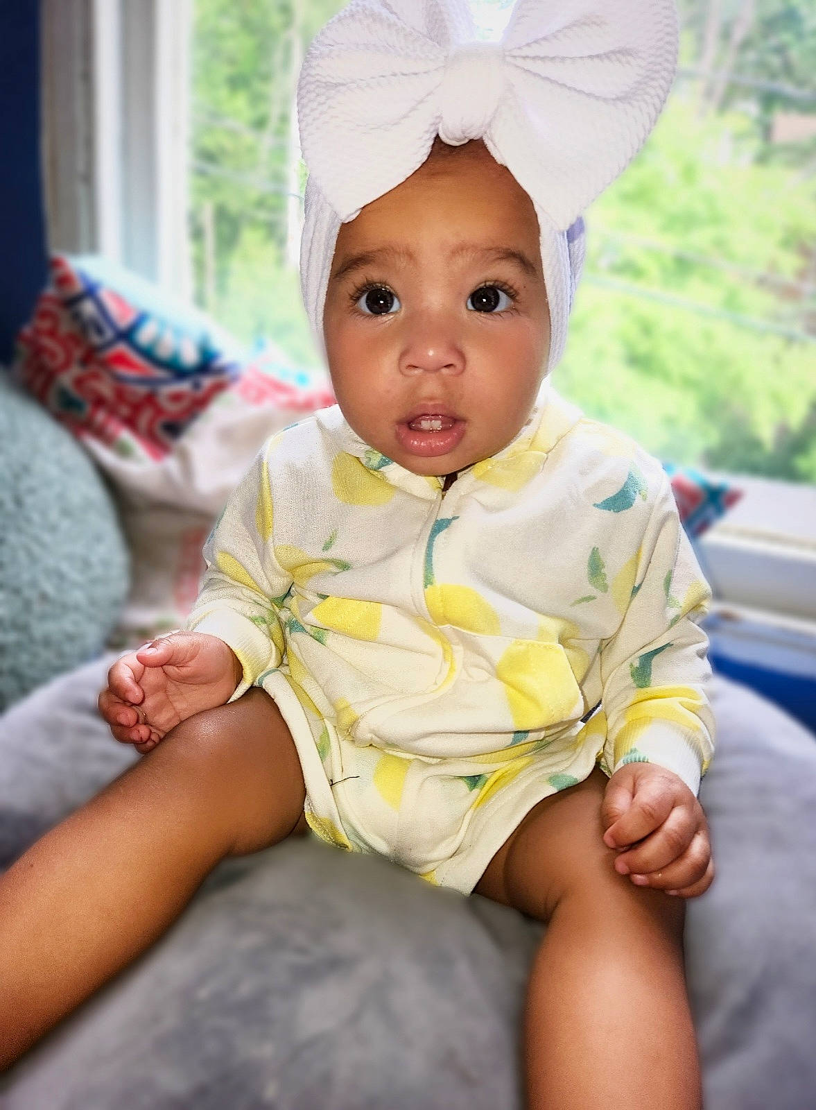 Divinity is registered to the contest to win money with this photo: baby, baby_toddler_clothing, cap, cheek, child, comfort, eye, facial_expression, fashion_accessory, fun, grass, happy, head, headgear, person, pink, sitting, skin, sleeve, smile