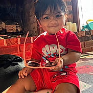 Veer joined the competition — help win amazing prizes! toddler, child, red_clothing, sunglasses, smile, indoor, brick_fireplace, mat, toy, window, natural_light, cute, playful, person, shorts, shirt, hand, face, hair, home