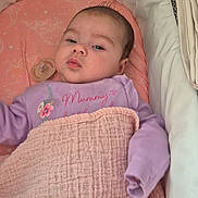 Leia-Marie is registered to the contest to win money with this photo: baby, bassinet, blanket, child, cozy, cushion, cute, face, indoor, infant, newborn, pacifier, person, pink, purple_clothing, resting, sleepy, soft_texture, text_on_clothing, young