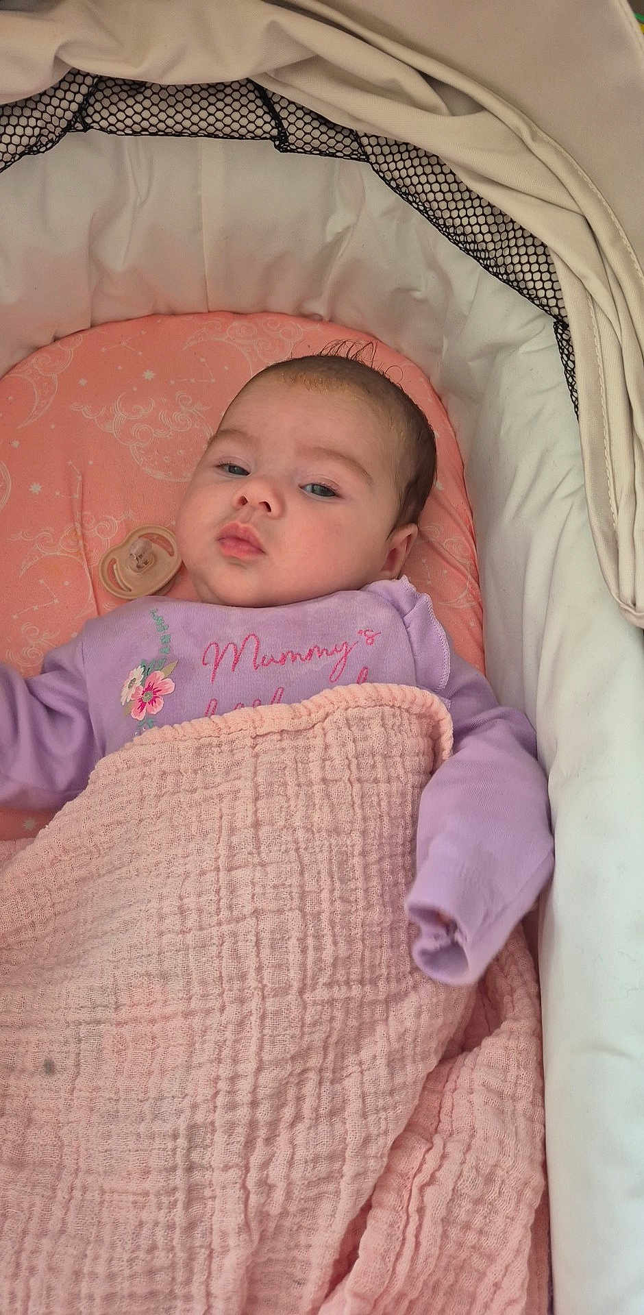 Leia-Marie is registered to the contest to win money with this photo: baby, bassinet, blanket, child, cozy, cushion, cute, face, indoor, infant, newborn, pacifier, person, pink, purple_clothing, resting, sleepy, soft_texture, text_on_clothing, young