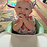 Gracie is registered to the contest to win money with this photo: baby, child, infant, headband, orange_bow, smiling, hands, baby_seat, high_chair, play_mat, toy, carpet, indoor, floor, earrings, clothing, person, cute, happy, portrait
