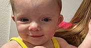 Gracie is registered to the contest to win money with this photo: baby, child, smile, face, person, indoor, tank_top, yellow, bow, winnie_the_pooh, pink, hair, skin, holding, cute, portrait, toddler, clothing, hand, young