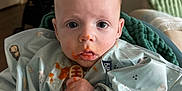 Mayer joined the competition — help win amazing prizes! baby, messy_face, bib, teething_toy, food_stains, blue_clothing, indoor, blanket, stroller, curious_eyes, child, sitting, infant, hand, mouth, face, person, portrait, young_child, home