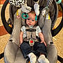 Mayer is registered to the contest to win money with this photo: baby, car_seat, infant, child, toy, hanging_toy, black_and_white, socks, jeans, seatbelt, curious, indoor, floor, child_safety, baby_clothing, head_support, playful, cute, person, portrait