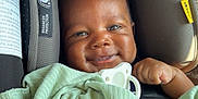 Wesley joined the competition — help win amazing prizes! baby, smile, blanket, car_seat, child, face, infant, cute, happy, indoors, protection, warning_label, pacifier, wrapped, clothing, seat_belt, safety, person, portrait, young