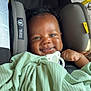 baby, smile, blanket, car_seat, child, face, infant, cute, happy, indoors, protection, warning_label, pacifier, wrapped, clothing, seat_belt, safety, person, portrait, young