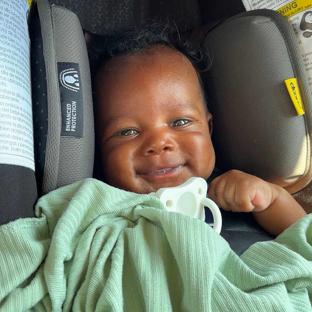 Wesley joined the competition — help win amazing prizes! baby, blanket, car_seat, child, clothing, cute, face, happy, indoors, infant, pacifier, person, portrait, protection, safety, seat_belt, smile, warning_label, wrapped, young