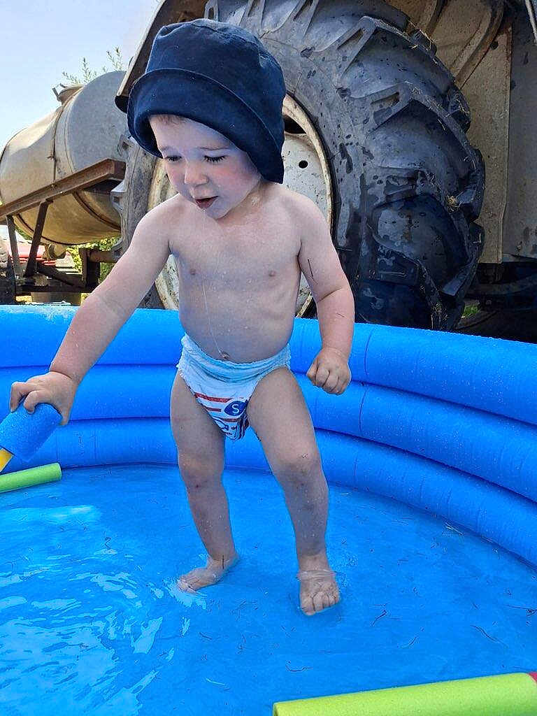 Khaël a rejoint le concours — aidez-le/la à gagner de superbes lots ! toddler, child, diaper, blue_pool, pool_noodle, water, hat, outdoor, tractor_tire, farm, summer, play, barefoot, sunlight, young_child, cute, fun, splash, blue, small_pool