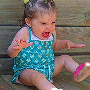 Théa participe au concours pour gagner de l'argent avec cette photo : toddler, child, blue_romper, flower_hair_accessory, wooden_steps, outdoor, happy, excited, sitting, barefoot, sunlight, playful, young_child, expression, summer, casual_clothing, cute, portrait, fun, daylight