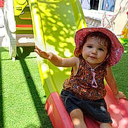 Théa participe au concours pour gagner de l'argent avec cette photo : backyard, child, grass, happy, hat, outdoor, person, pink, plastic, play, playground, shadow, shoes, shorts, slide, smiling, summer_clothing, sunlight, toddler, toy