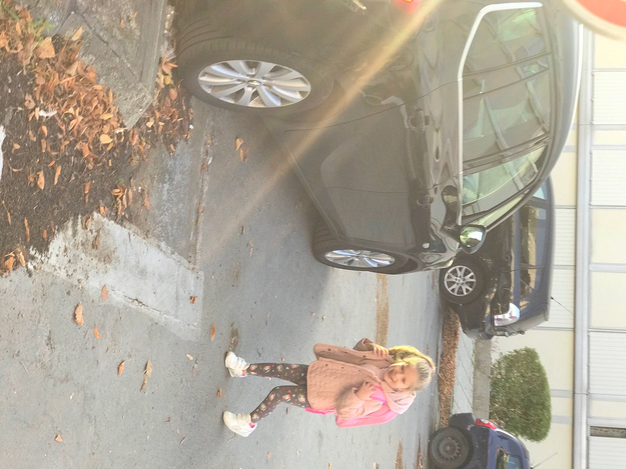 Lara participe au concours pour gagner de l'argent avec cette photo : asphalt, automotive_design, automotive_exterior, automotive_lighting, automotive_tire, bumper, car, dress, fender, hood, joy, motor_vehicle, person, plant, road_surface, sidewalk, tints_and_shades, tire, vehicle, vehicle_door