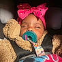 baby, sleeping, pacifier, pink_bow, car_seat, blanket, teddy_bear_jacket, child, infant, cozy, cute, headband, straps, seatbelt, indoors, closeup, peaceful, adorable, warm, resting
