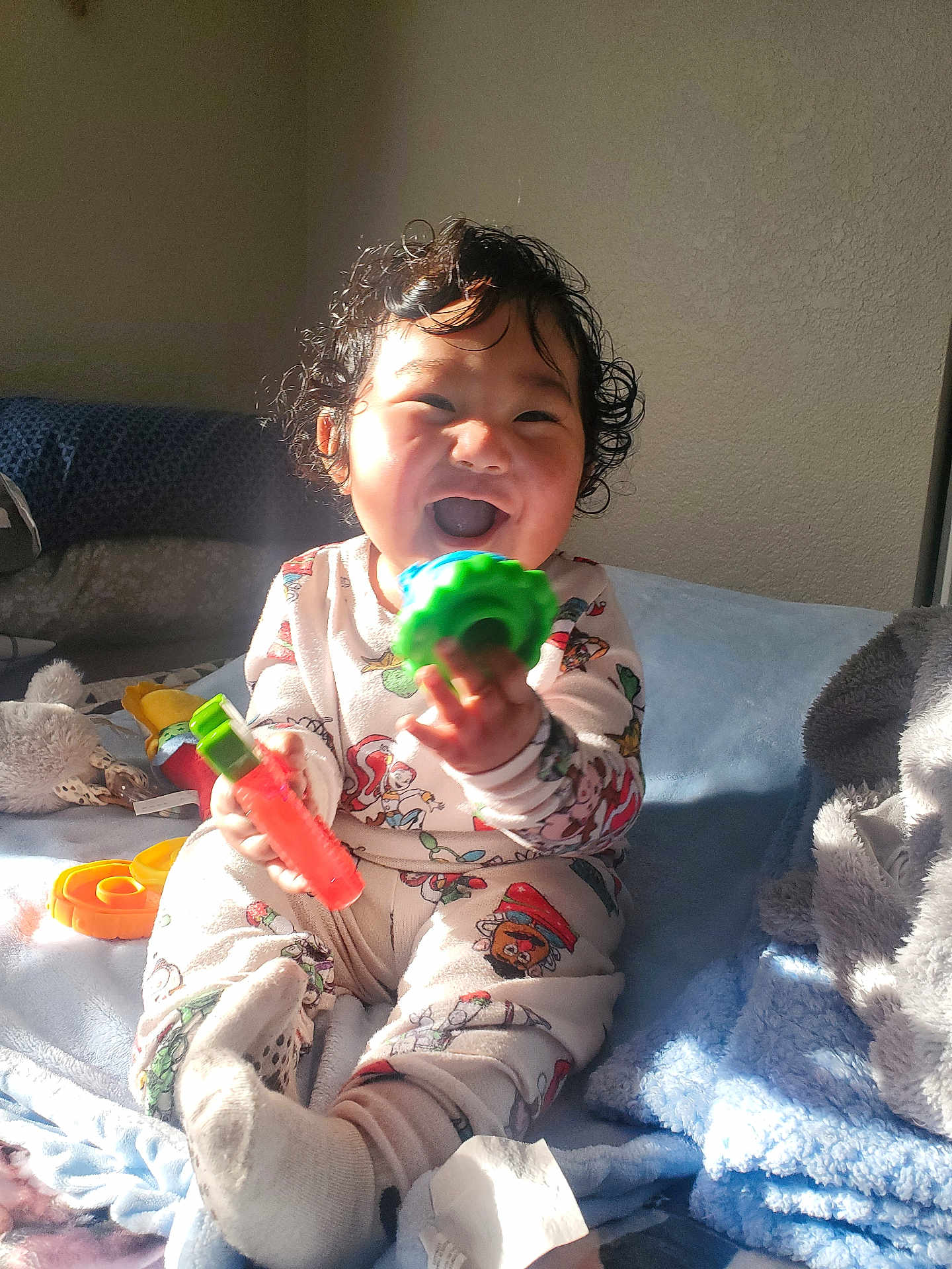 Mercellus Hendson joined the competition — help win amazing prizes! baby, bed, blanket, child, colorful_toy, cozy, curly_hair, happy, indoor, infant, laughing, onesie, pajamas, plush_toy, sitting, smiling, sock, sunlight, teething_toy, toy