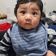 Mercellus Hendson joined the competition — help win amazing prizes! baby, bib, blurry_background, child, curly_hair, cute, expression, face, focus, gray_pants, hand, indoor, infant, navy_sweater, portrait, sitting, soft_lighting, striped_clothing, wide_eyes, young_child