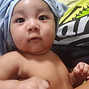 Mercellus Hendson joined the competition — help win amazing prizes! baby, child, face, skin, arm, hand, towel, turban, person, adult, holding, shirt, graphic, indoor, closeup, expression, curious, candid, portrait, human