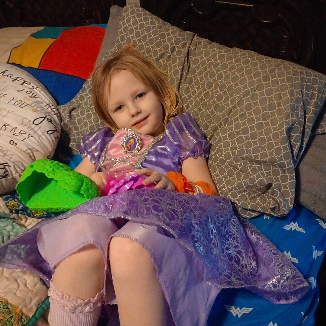 Willow is registered to the contest to win money with this photo: accessories, bed, blanket, child, clothing, couch, cushion, dress, face, female, furniture, girl, head, homedecor, jewelry, necklace, person, photography, pillow, portrait