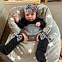 Bonnie-Rae joined the competition — help win amazing prizes! baby, infant, child, black_and_white, houndstooth, headband, bow, leg_warmers, cushion, star_pattern, carpet, indoor, home_decor, mug, wooden_furniture, photo_frame, person, clothing, seated, expression