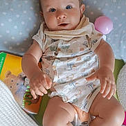 Loé participe au concours pour gagner de l'argent avec cette photo : baby, blanket, blue_eyes, book, child, clothing, curious, cute, diaper, face, foot, hand, indoor, infant, lying_down, pillow, polka_dot, skin, soft_toys, toy