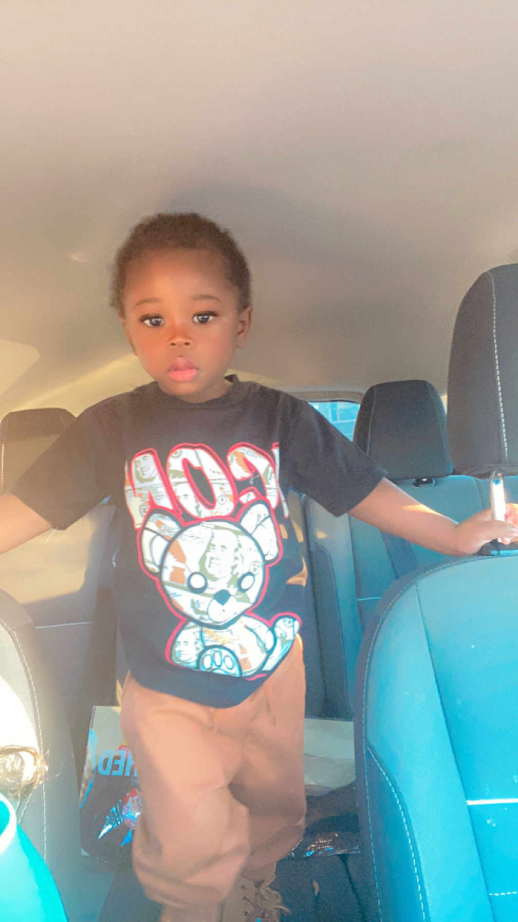 Jahsir is registered to the contest to win money with this photo: car_interior, casual, child, clothing, cute, face, hand, head, indoors, pants, person, portrait, seat, seatback, standing, sunlight, transportation, tshirt, window, young