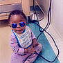 baby, bib, black_cable, blue, cabinet, cable, child, cute, floor, indoor, lamp, pajamas, person, playful, purple, reflection, smiling, sunglasses, toddler, wall