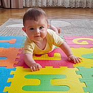 Alex a rejoint le concours — aidez-le/la à gagner de superbes lots ! baby, child, colorful_mat, crawling, curtains, cute, eyes, face, floor, foam_puzzle, hand, home_interior, indoors, infant, lace_curtains, person, playtime, wooden_floor, yellow_clothing, young_child