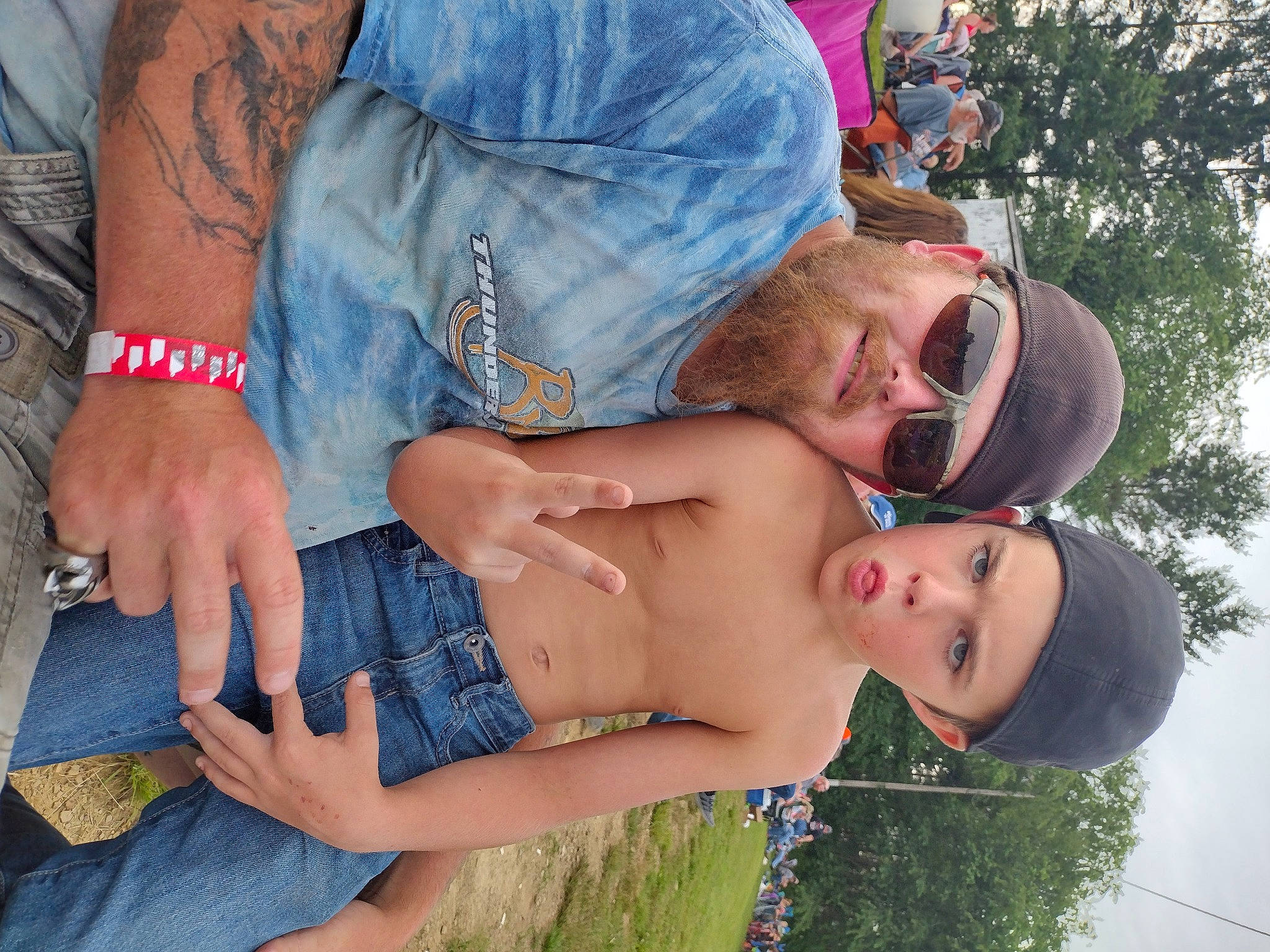Gavin is registered to the contest to win money with this photo: arm, blue, eyewear, gesture, glasses, grass, hand, happy, hat, headwear, interaction, jeans, joint, leg, mouth, muscle, person, plant, shoulder, sky