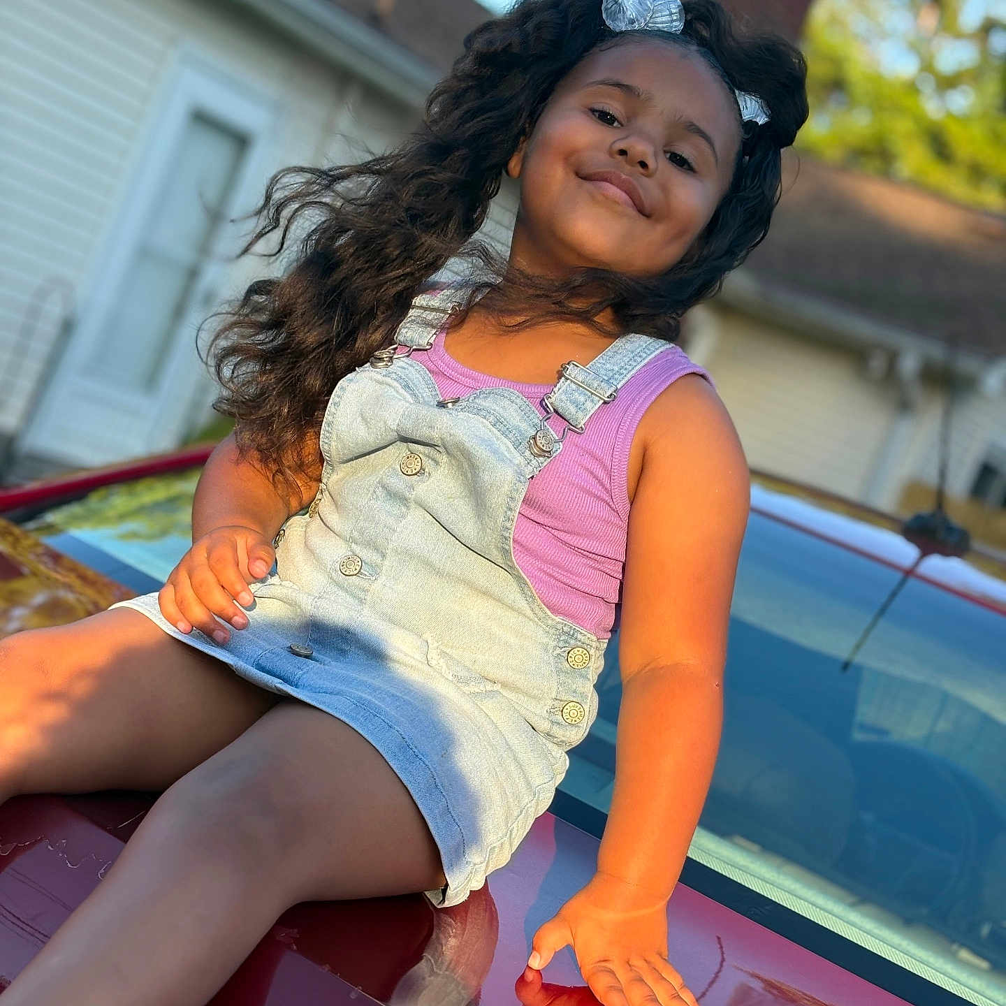 Zylahni is registered to the contest to win money with this photo: car, casual, child, denim_dress, girl, golden_hour, hand, happy, house, legs, long_hair, outdoor, portrait, red_car, reflection, smile, suburban, sunlight, tank_top, window