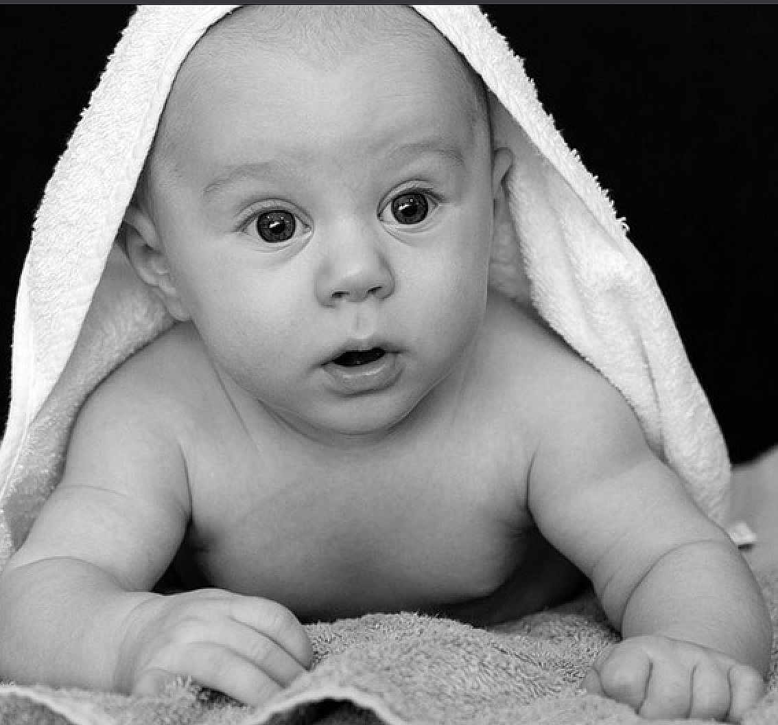 Pooty is registered to the contest to win money with this photo: baby, towel, black_and_white, infant, portrait, curious, face, skin, eyes, hands, lying_down, texture, closeup, expression, cute, child, newborn, soft_light, monochrome, background