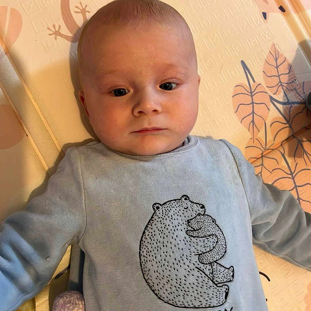 Ezio a rejoint le concours — aidez-le/la à gagner de superbes lots ! animal, applique, baby, blanket, bodypart, clothing, face, finger, hand, head, number, pattern, person, photography, portrait, sitting, sleeve, symbol, t_shirt, text