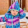 Mary-Alice is registered to the contest to win money with this photo: child, toddler, winter_jacket, hood, colorful_clothing, outdoor, snow, bench, blue_eyes, curious_expression, cold_weather, sitting, face, young_child, playful, snowy_background, warm_clothing, cute, portrait, daylight